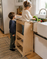 Two children at the Learning Tower washing vegetables together