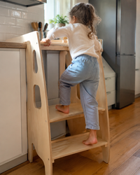 Child climbing independently into the Learning Tower