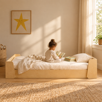 Toddler reading a picture book while sitting on the Tumbleroot Story Nook Bed